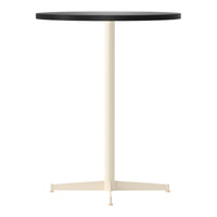 Round black tabletop with a cream-colored base, featuring a minimalist design and solid colors.