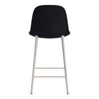 Black upholstered bar stool with sleek silver legs, featuring a minimalist design. Perfect for modern spaces.