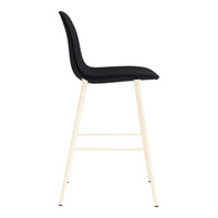 Black upholstered bar stool with sleek, minimalistic design and light beige metal legs.