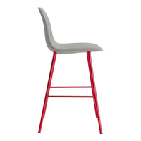 Gray upholstered barstool with sleek red metal legs, showcasing a modern design and minimalist aesthetic.