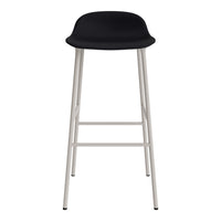 Black seat with sleek curves and minimalist white metal legs. Modern design ideal for contemporary decor.