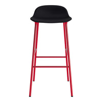 Black bar stool with a smooth seat and vibrant red metal legs. Modern design for stylish interiors.