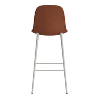 Brown upholstered bar stool with a sleek white metal frame, featuring a minimalist design. Perfect for modern spaces.