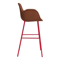 Brown upholstered bar stool with vibrant red metal legs, showcasing a sleek, modern design.