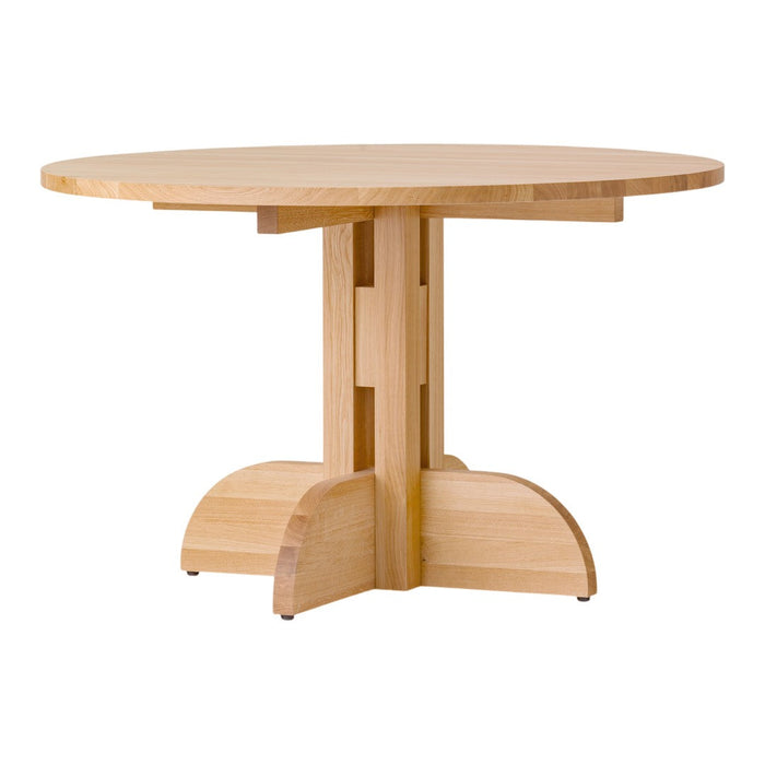 Light-colored wooden round table with a smooth surface and a unique, modern base design. Perfect for contemporary spaces.