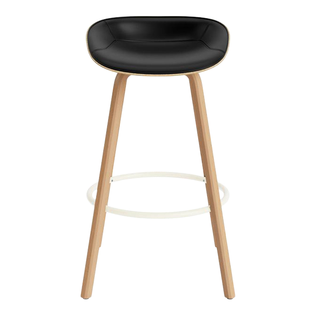 Black padded seat bar stool with natural wood legs and white footrest. Modern design for stylish interiors.