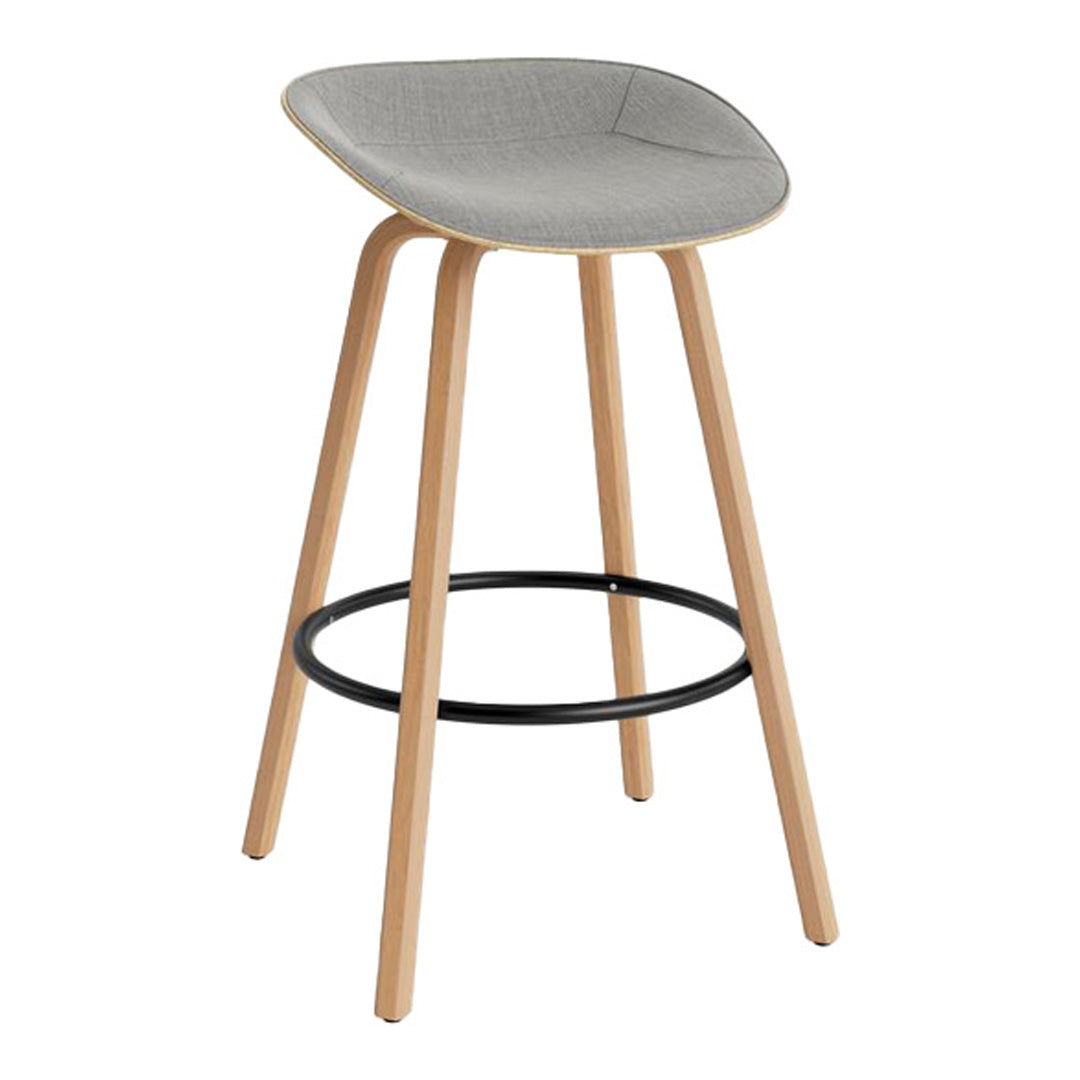 Gray upholstered bar stool with light wood legs and a black metal footrest. Sleek and modern design.