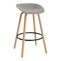 Gray upholstered bar stool with light wood legs and a black metal footrest. Sleek and modern design.