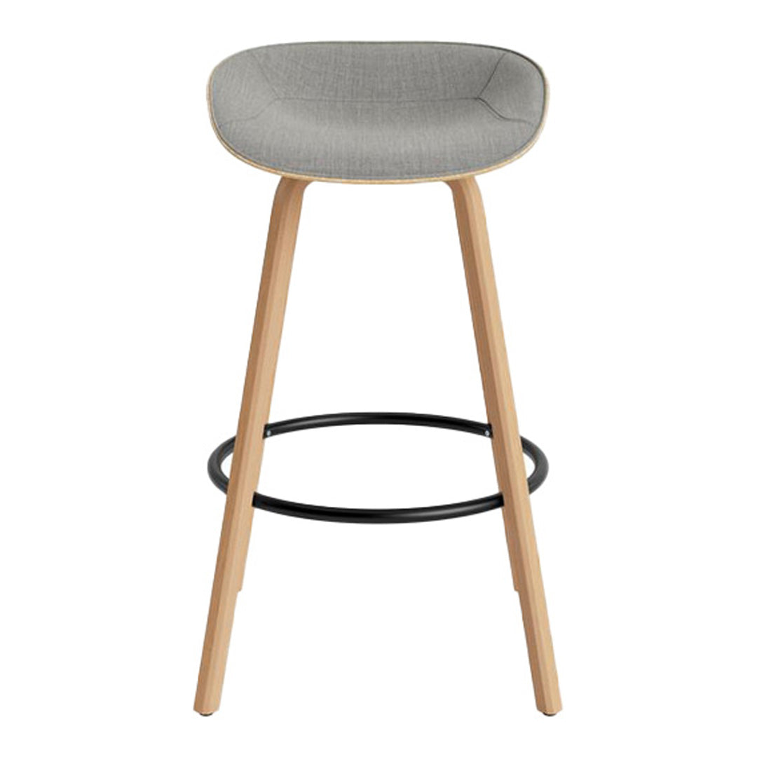 Gray upholstered bar stool with natural wood legs and a black metal footrest, showcasing a modern minimalist design.