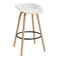 White speckled seat with natural wood legs and a black metal footrest, modern and minimalist design.