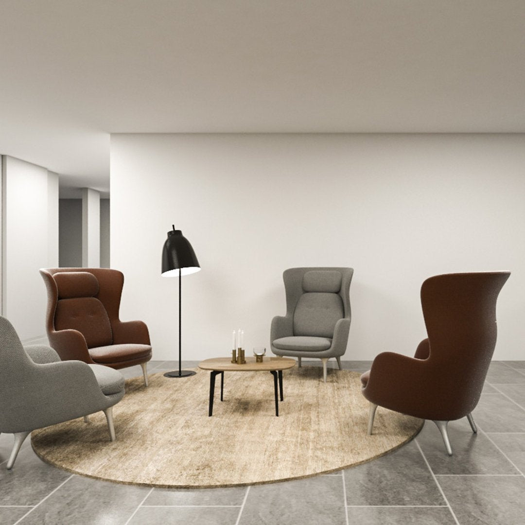 Stylish chairs in rich brown and soft gray, paired with a beige round rug, against a modern gray tile floor.
