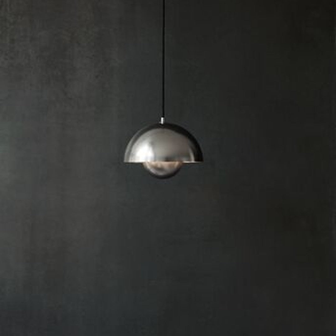 Silver dome pendant light against a dark textured wall, featuring a sleek and modern design.