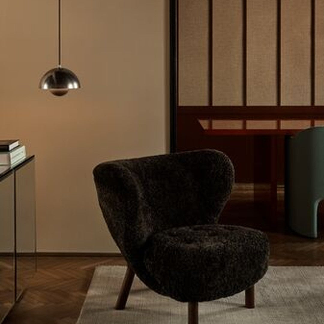 Cozy dark brown chair with plush textured fabric, complemented by warm wooden accents in a minimalist setting.