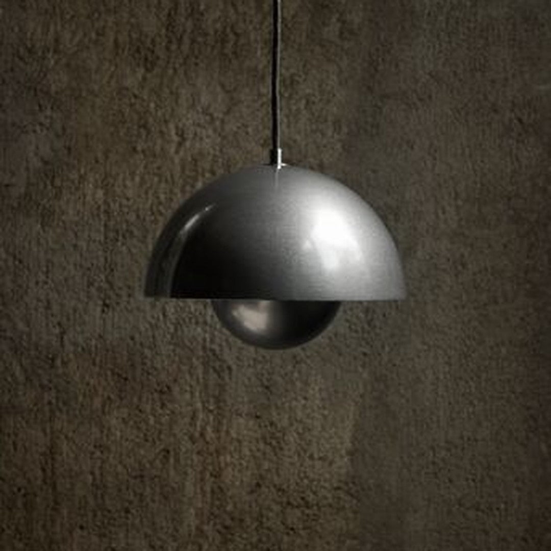 Modern black and silver pendant lamp with a sleek, half-dome shape against a textured dark background.