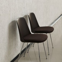 Brown upholstered chairs with sleek, modern design and chrome legs, set against a neutral textured background.
