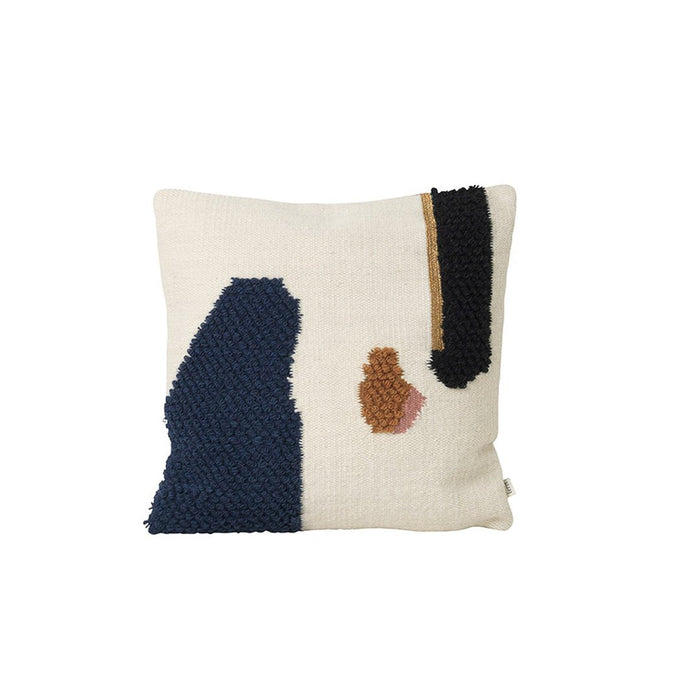 Textured throw pillow featuring navy, black, and earthy tones on a cream background with abstract patterns.