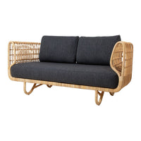 Rattan loveseat with a natural woven frame and dark gray upholstery, featuring a modern, minimalist design.