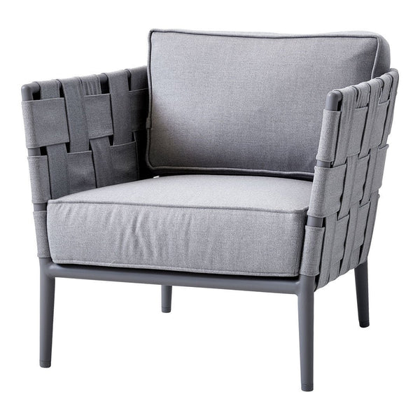 Grey woven chair with a gray fabric cushion and sleek metal legs, featuring a modern, minimalist design.