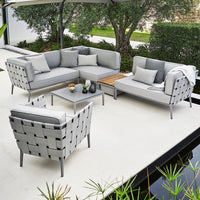 Gray outdoor sectional sofa with woven detailing and light cushions, complemented by a wooden coffee table.