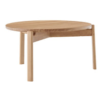 Round wooden coffee table in natural oak finish, showcasing a smooth texture and minimalist design.