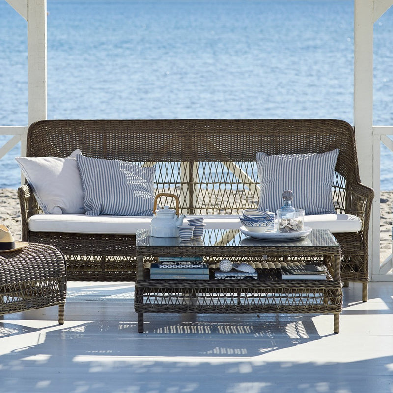 Coastal wicker sofa set with gray cushions and striped patterns, perfect for outdoor relaxation by the water.