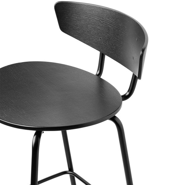 Black wooden stool with a smooth round seat and curved backrest, featuring a minimalist design and matte finish.