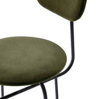 Olive green velvet chair with sleek black metal frame, featuring minimalistic design and soft textures.