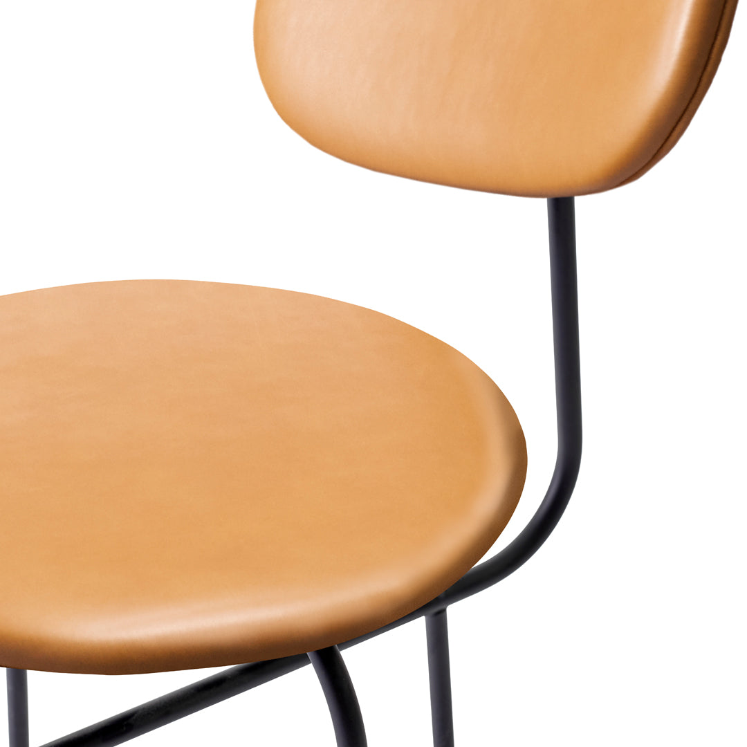 Tan leather chair with smooth surfaces and sleek black metal frame, perfect for modern decor.