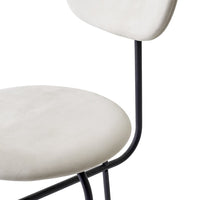 Cream-colored upholstered chair with a sleek black metal frame, featuring a minimalist design and smooth surfaces.