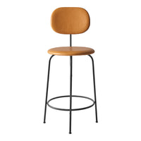 Modern bar stool featuring a warm tan seat, sleek black metal legs, and a minimalistic design. Perfect for stylish spaces.