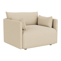 Beige armchair with a modern, minimalist design and soft, textured fabric, featuring two decorative cushions.