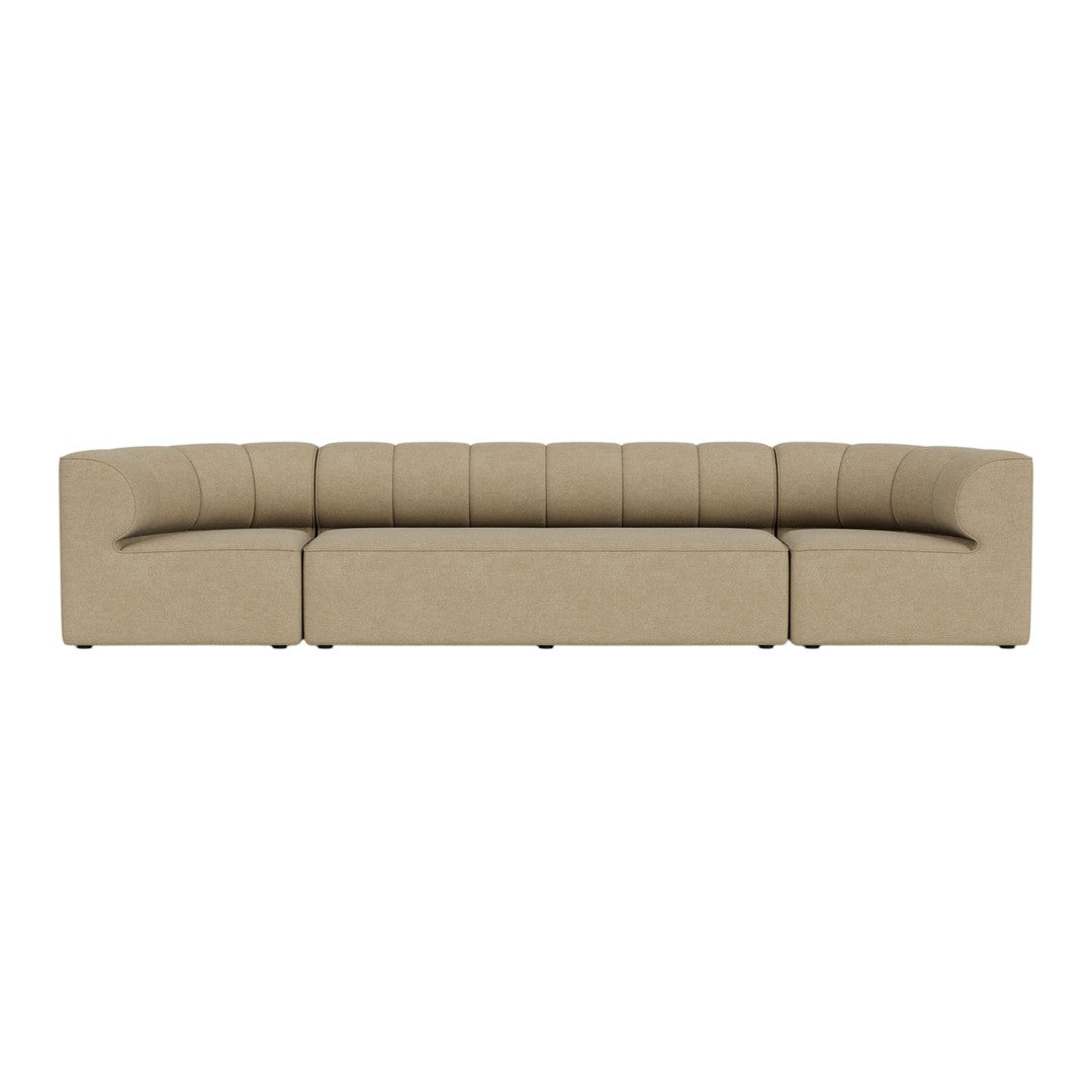 Beige curved sectional sofa with vertical tufted pattern, perfect for modern living spaces.