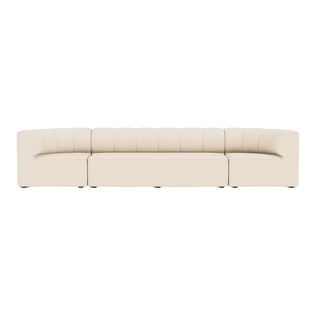 Beige curved sofa with tufted detailing, featuring a smooth, minimalist design for modern decor.