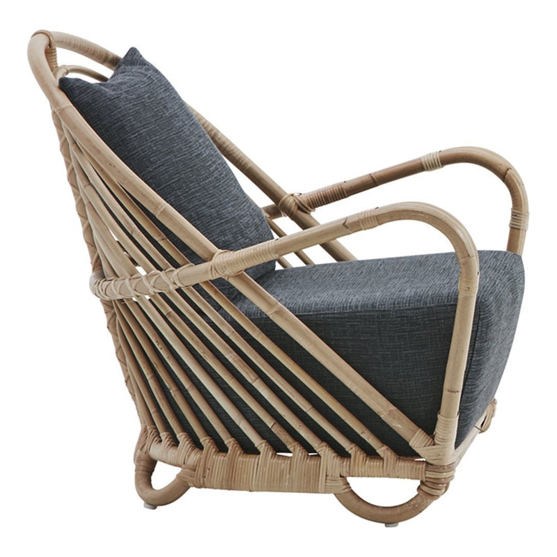 Rattan chair with a sleek, natural wood finish and a dark gray cushion, featuring a striped pattern in the backrest.