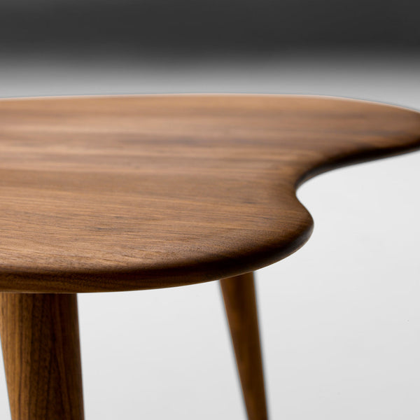 Wooden table with a smooth, organic shape and rich brown tones, featuring natural wood patterns and a sleek finish.