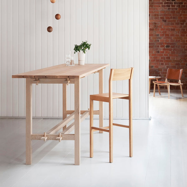 Light wood dining table and chair set with a natural finish in a minimalist, modern setting.