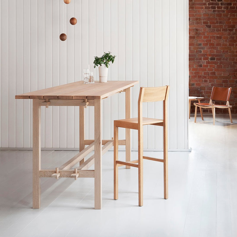 Light wood dining table and chair set with a natural finish in a minimalist, modern setting.