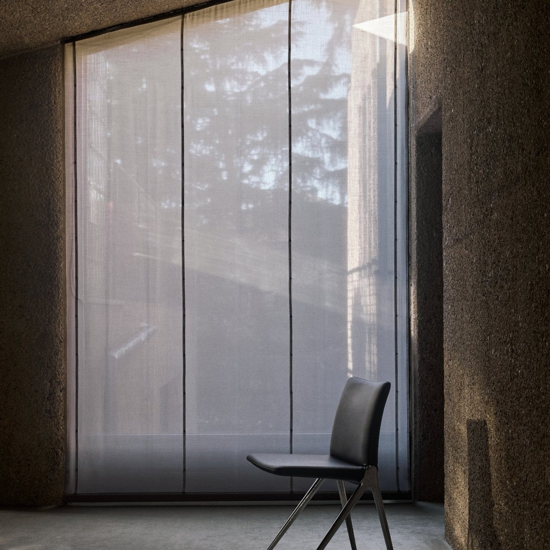 Light gray sheer curtains with vertical stripes and soft texture, enhancing a modern interior space.