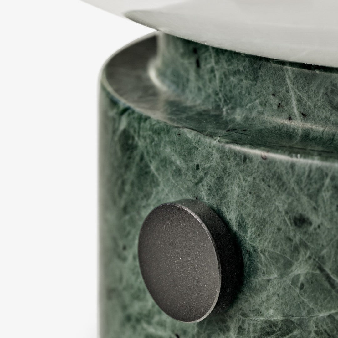 Green marble base with subtle veining and a sleek black accent button on a minimalist design.