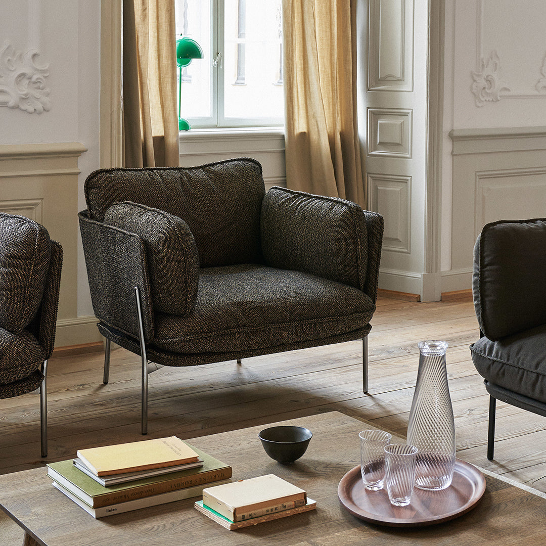 Stylish dark gray upholstered armchair with soft textured fabric and sleek metal legs, perfect for modern interiors.