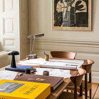"Contemporary workspace featuring warm wood tones, sleek black accents, and vibrant yellow book cover against neutral walls."