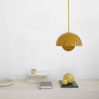 Yellow dome pendant light hanging above a minimalist table with neutral tones and subtle textures.