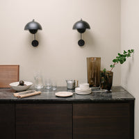 Elegant black and gold decor with neutral tones, showcasing modern patterns in glass and ceramic tableware.