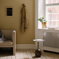 Warm beige walls, neutral tones in furniture, earthy textures, and a sleek black and brown table create a cozy, modern atmosphere.