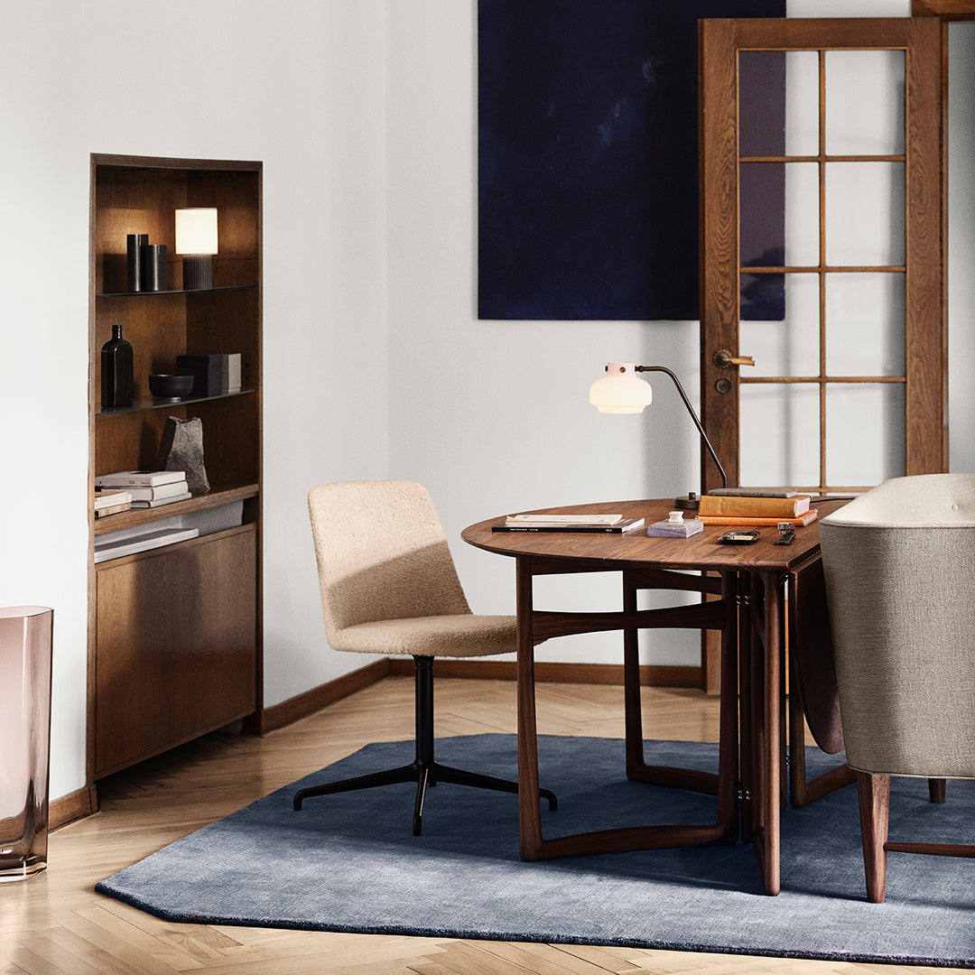 Modern office setup featuring neutral beige tones, rich wood textures, and a deep blue rug for elegant contrast.