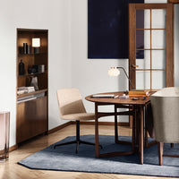 Modern office setup featuring neutral beige tones, rich wood textures, and a deep blue rug for elegant contrast.