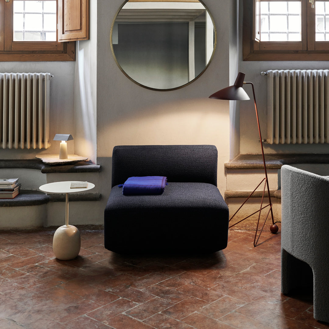 Stylish black sofa with a smooth texture, complemented by a vibrant purple throw and earthy decor tones.