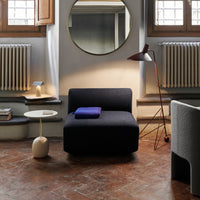 Stylish black sofa with a smooth texture, complemented by a vibrant purple throw and earthy decor tones.