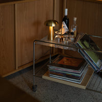 "Stylish metal and wood table featuring warm lighting, textured vinyl records, and sleek glassware."