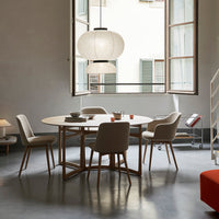 Modern wooden dining table with light gray chairs, accented by soft beige and white textures in a stylish interior.